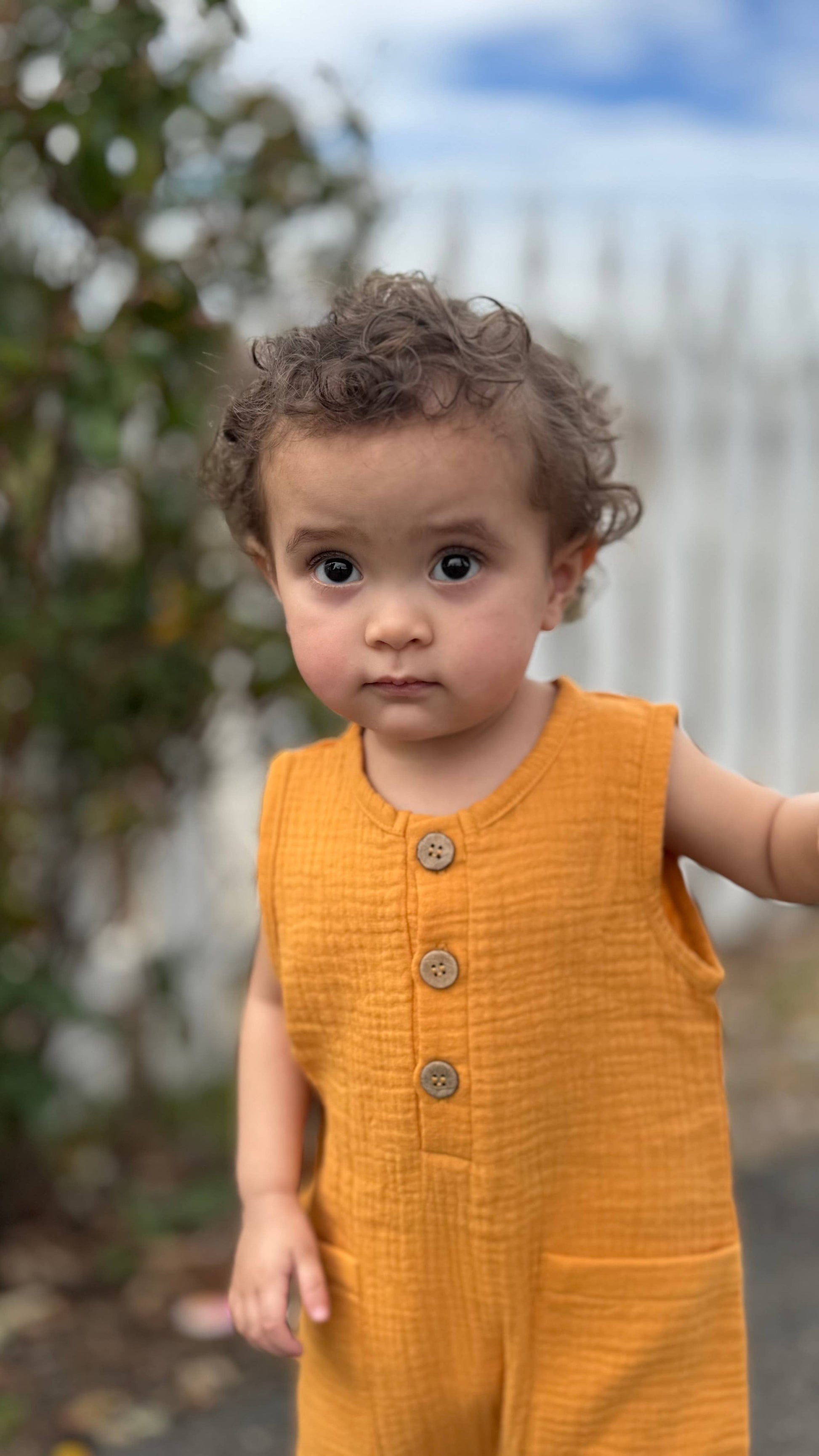 Sleeveless organic gender neutral muslin romper in Marigold